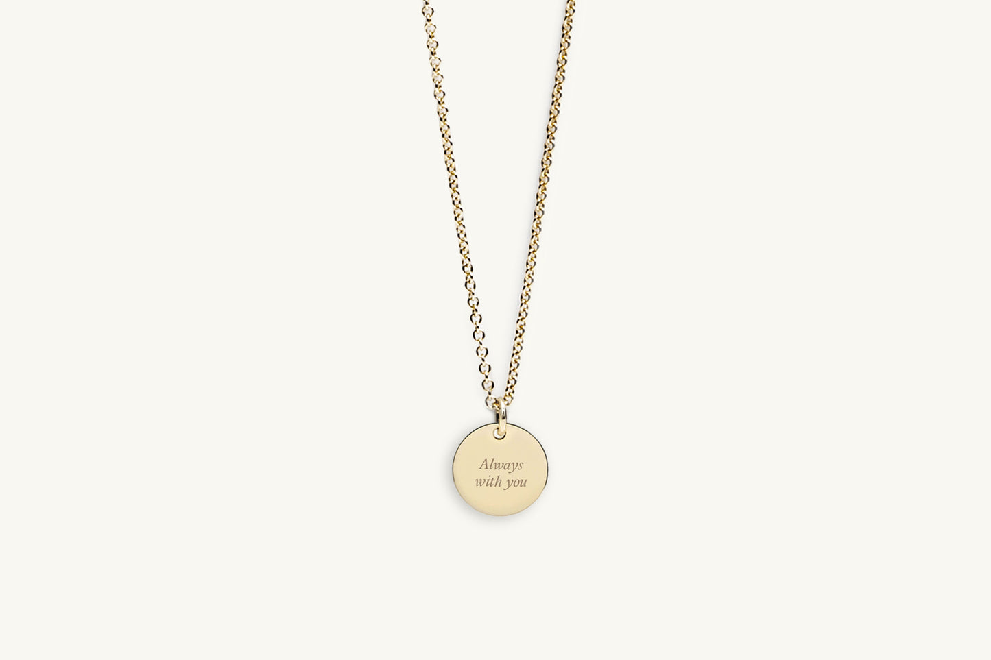 Gold necklace with message engraved on a round pendant on a white background
