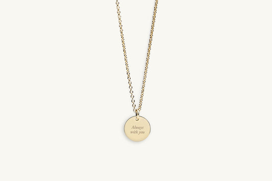 Gold necklace with message engraved on a round pendant on a white background