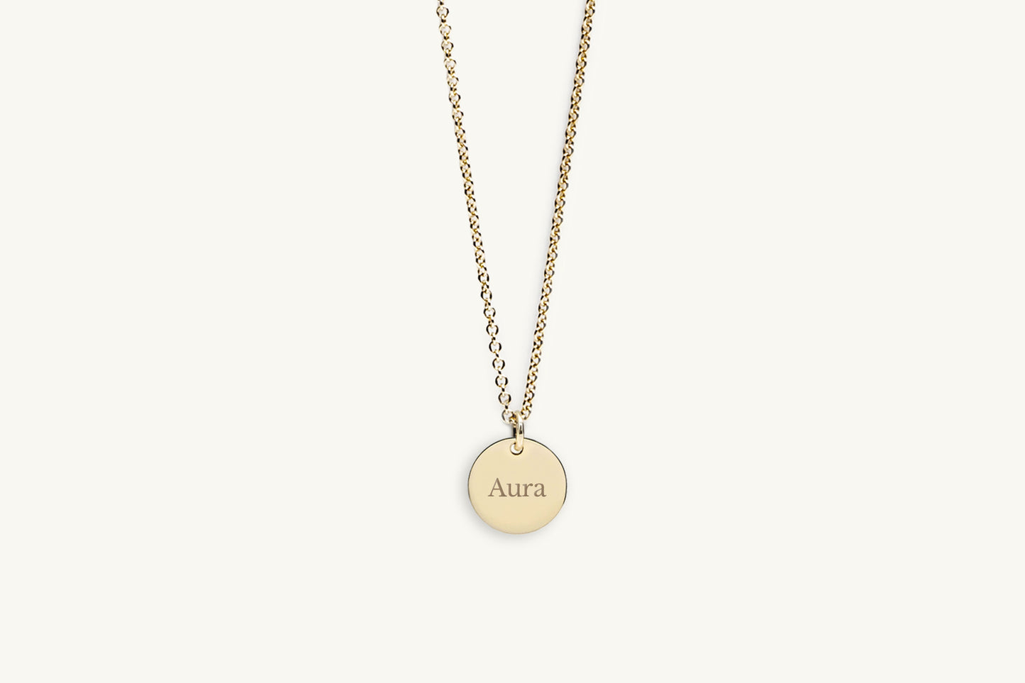 Gold necklace with a round pendant on a white background